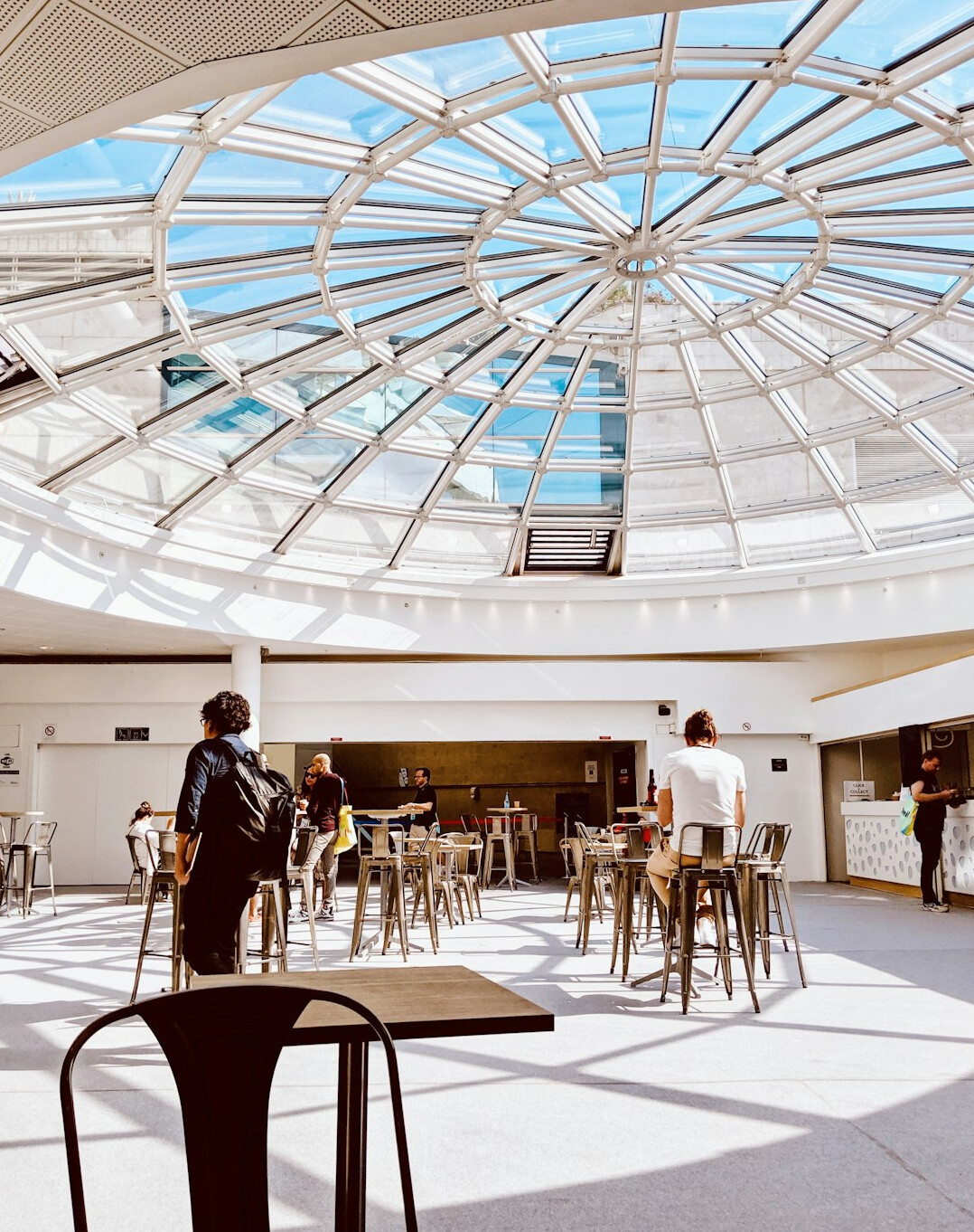 Groupe diversifié de professionnels discutant autour d'une table dans une salle lumineuse